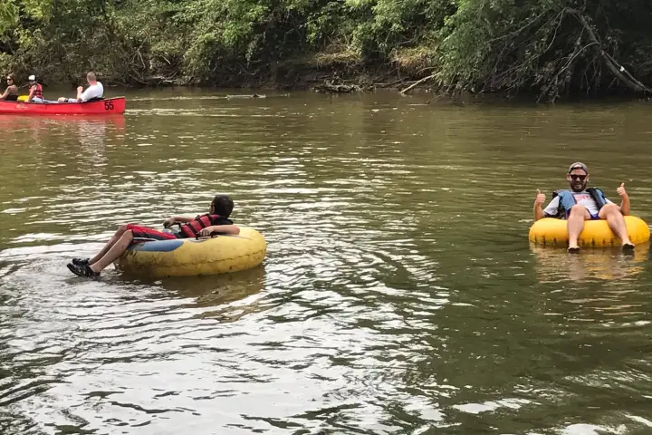 a group of people rowing a boat floating on a body of water