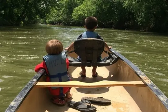 a man riding on the back of a boat in the water