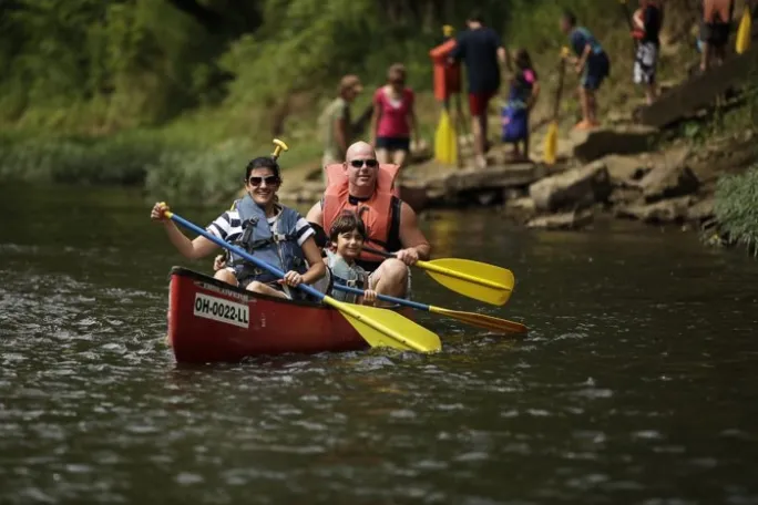 a man riding on the back of a boat in a body of water