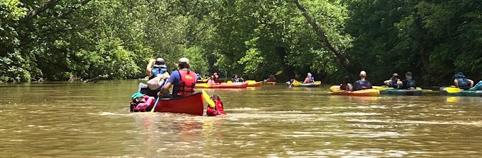 a group of people riding on the back of a boat in the water